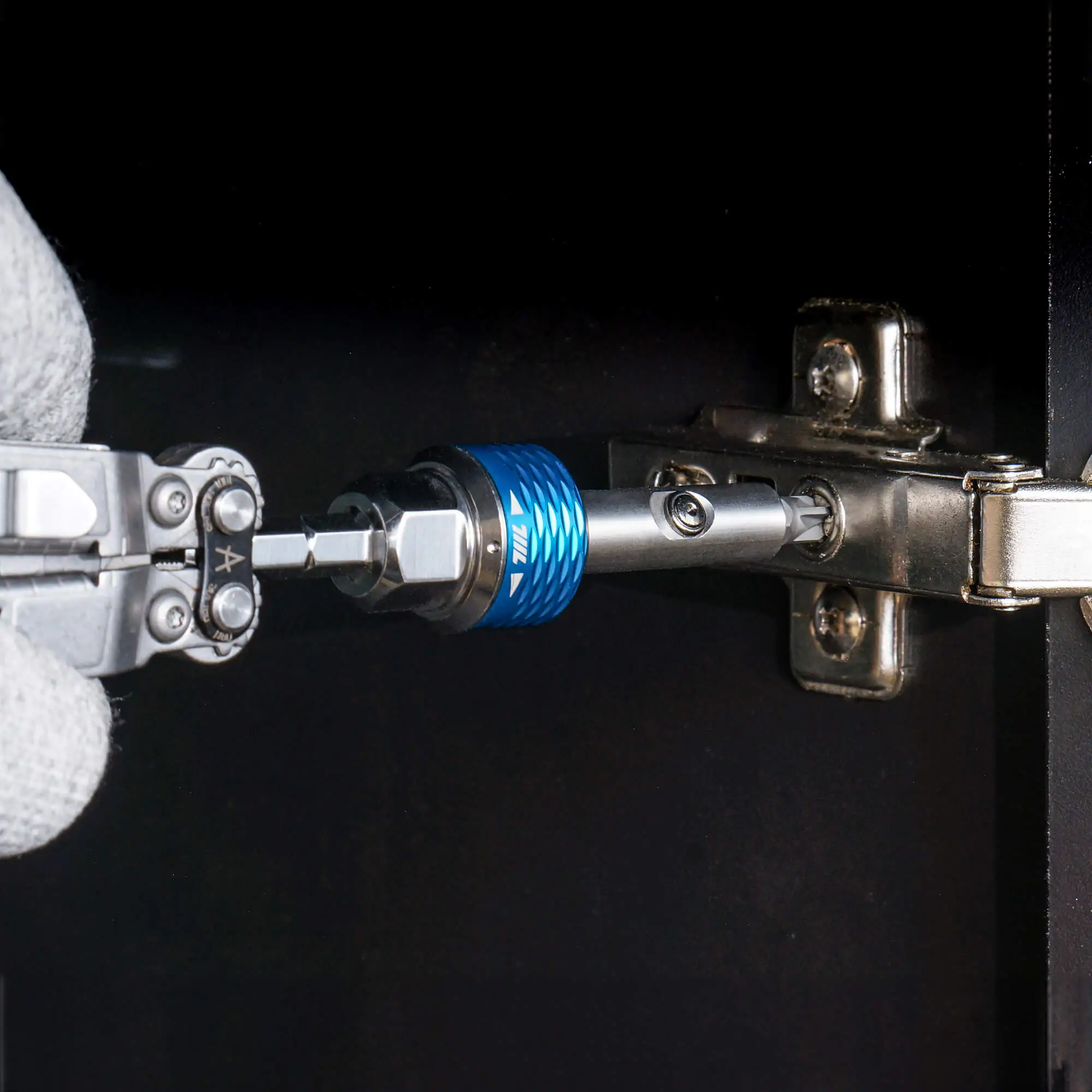 Tightening a cabinet hinge bolt with the 711L inline ratchet driver HEX on a wooden door frame