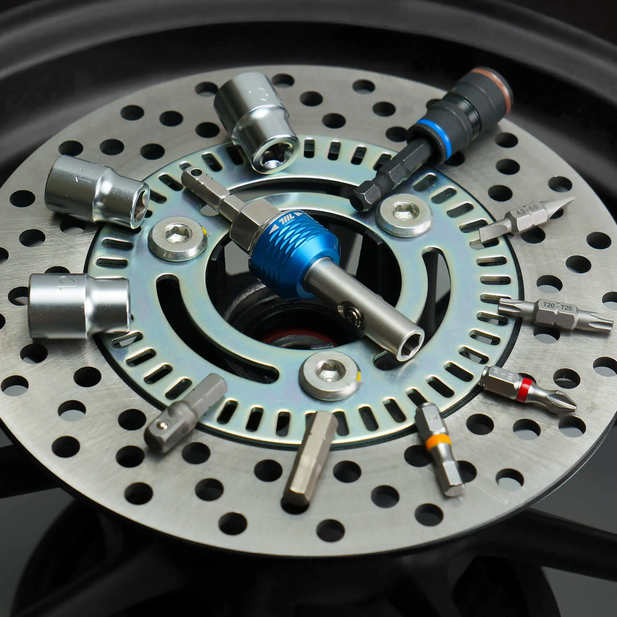 711L inline ratchet driver HEX inserted into a perforated brake rotor disc with scattered bits around it